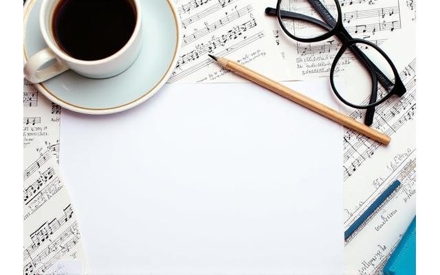 Partition de musique et notes manuscrites sur une table avec un crayon